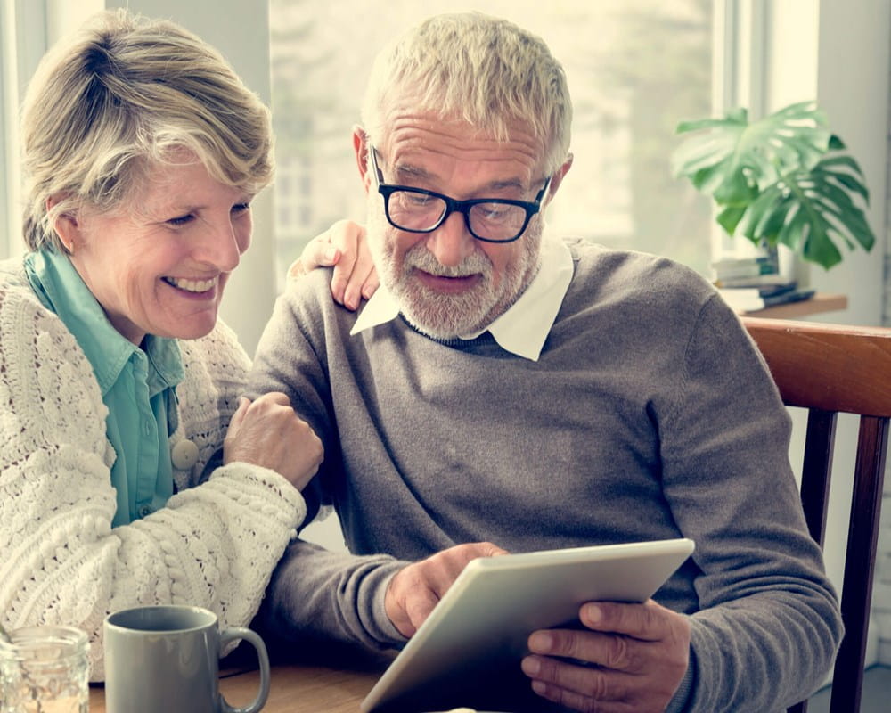 Older couple reading a tablet