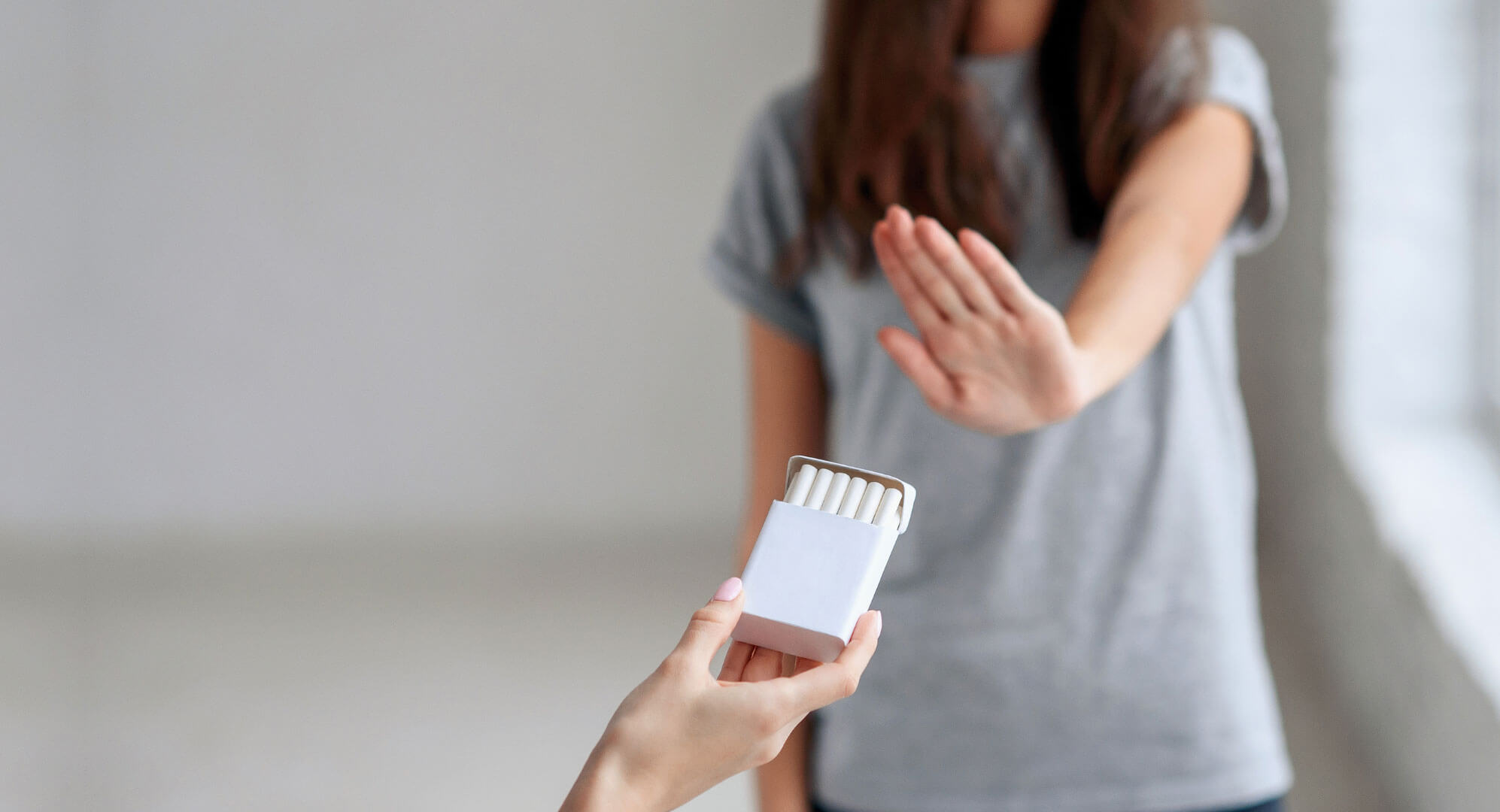 Person rejecting pack of cigarettes