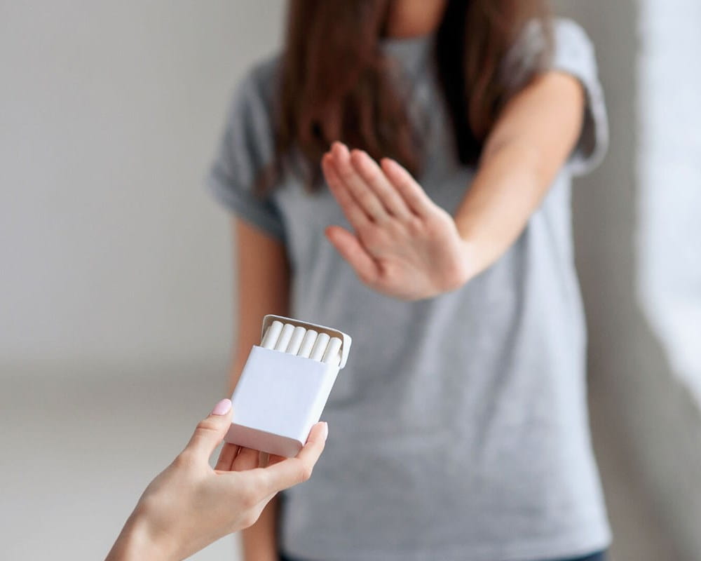 Person rejecting pack of cigarettes