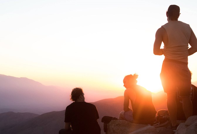 Stock photo of people in mountain watching sunrise/sunset