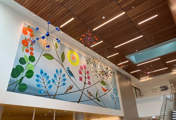 Artist: Rebecca Baird | Title: All My Relations | Location: Main lobby, Crisis & Critical Care Building | This mural and sculpture  incorporates a selection of flora and fauna imagery that will portray the fluidity and dynamic interconnectedness of all nature. The series of seven glass satellite sculptures symbolically suggest a cosmic perspective. The choice to create seven satellite sculptures reflects the importance of the ‘number seven’ within Indigenous traditional teachings. The seed-like, star-like details of the sculptures create a visually descriptive bridge connecting the concept of the cosmos to the mural imagery.