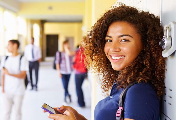 Teenage girl standing in school hallway