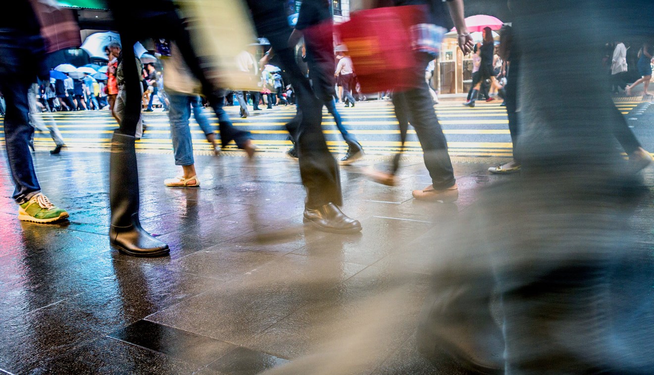 Blurred image focusing on legs and feet of people crossing a street