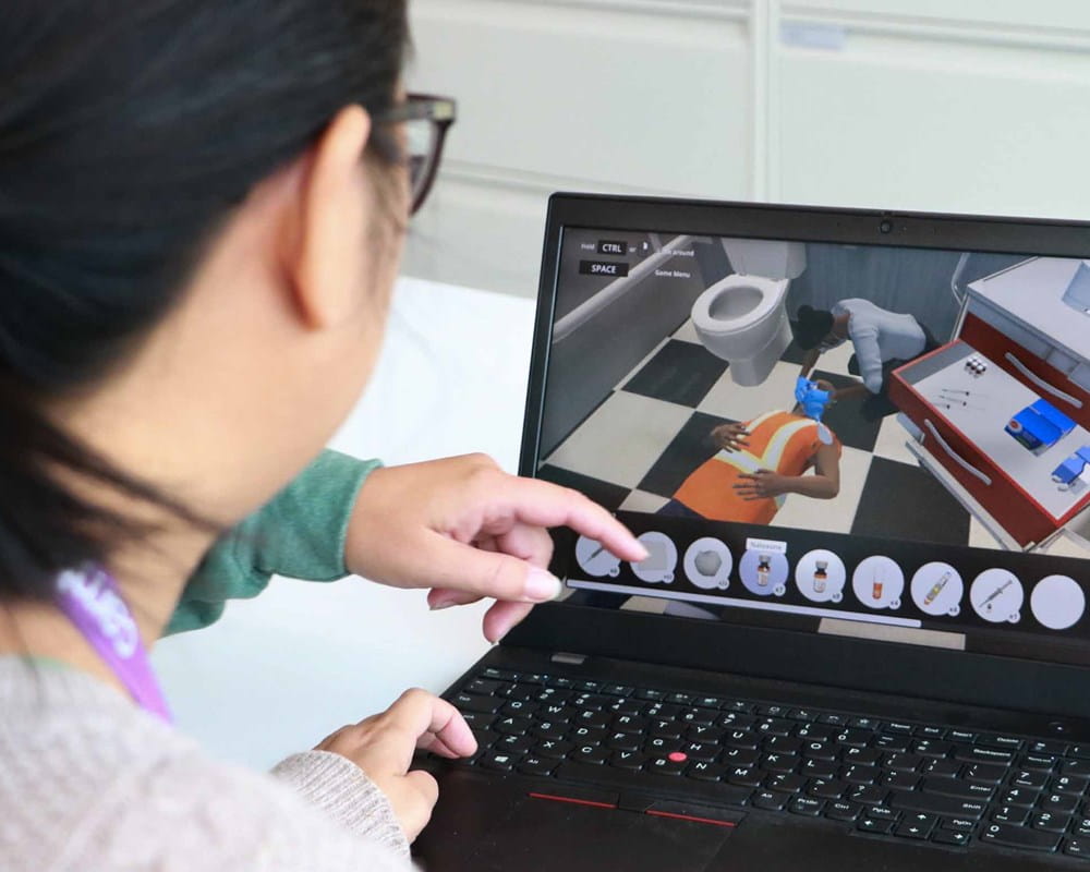 Person on a laptop going through a virtual reality training simulation