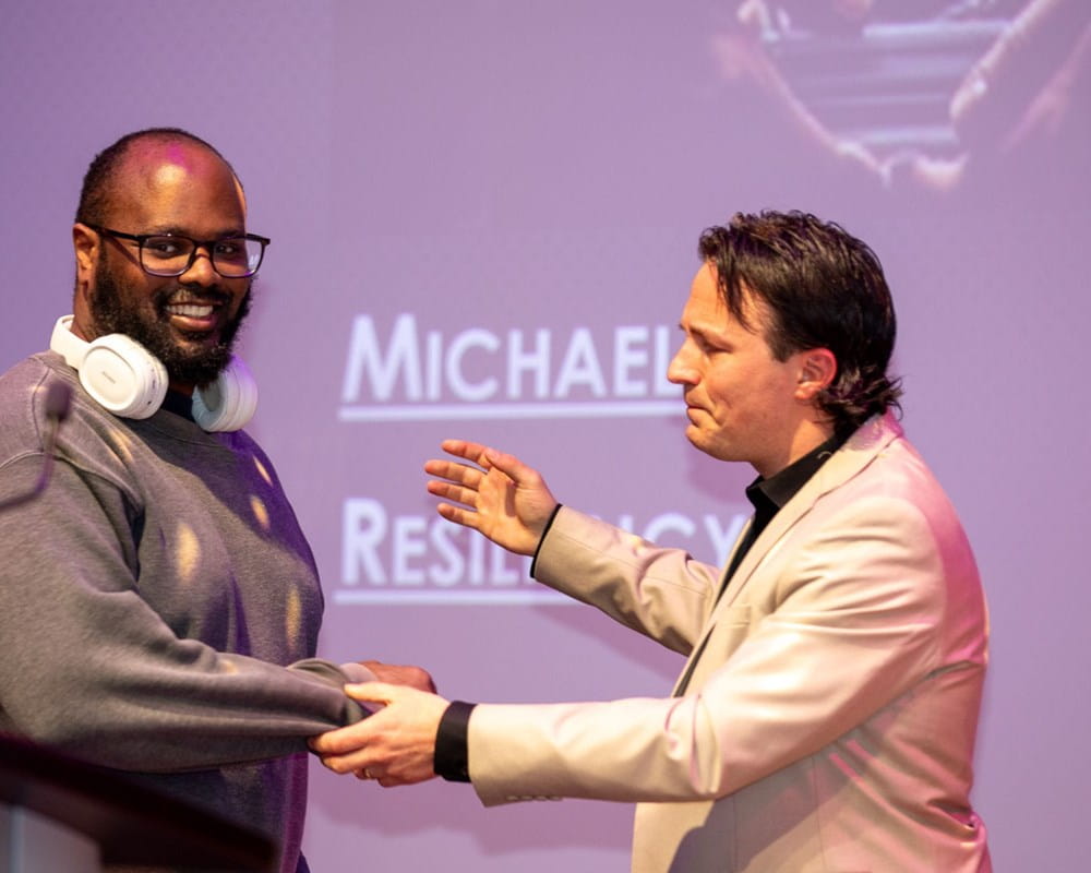 A FACT awards host reaches to hug a client