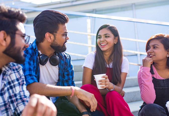 South Asian young adults sitting on bleachers 