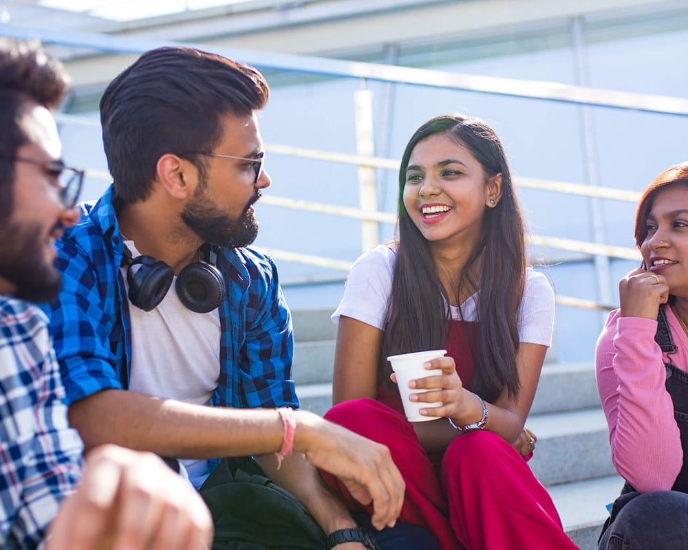 South Asian young adults sitting on bleachers 