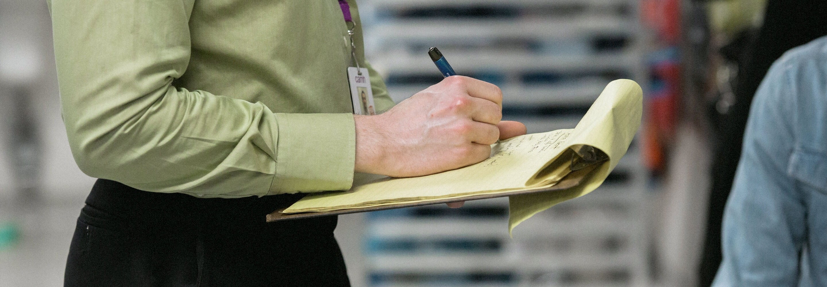 A woman  writes on a clipboard.