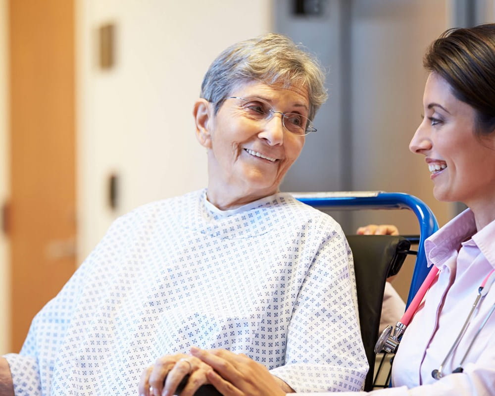 Doctor helping elderly woman. Doctor also happens to be female.