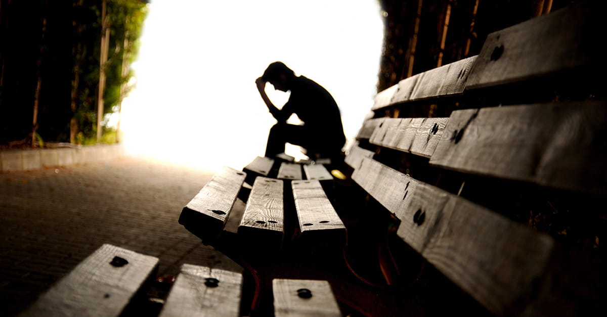 Depressed man sitting on a bench