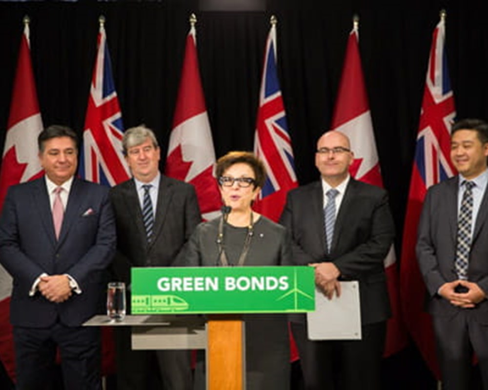 CEO, Catherine Zahn speaking in front of a podium with the sign