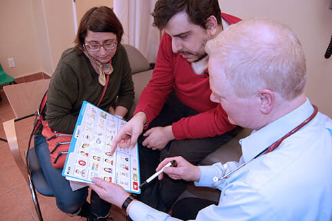 A clinician showing his patient and caregiver the Health Check toolkit 