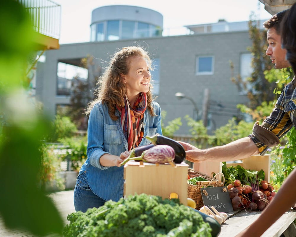 Couple talking to vendor at community Farmers Market.