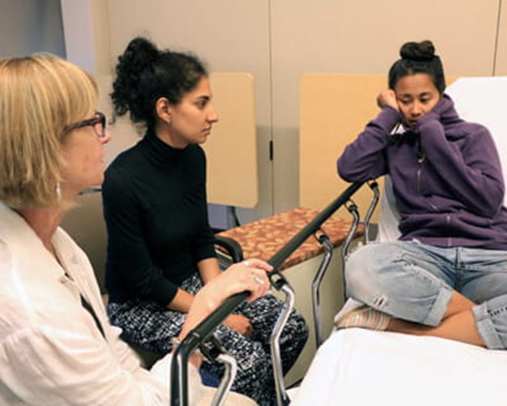 A professional actor plays the part of a teen patient during a mental health simulation.