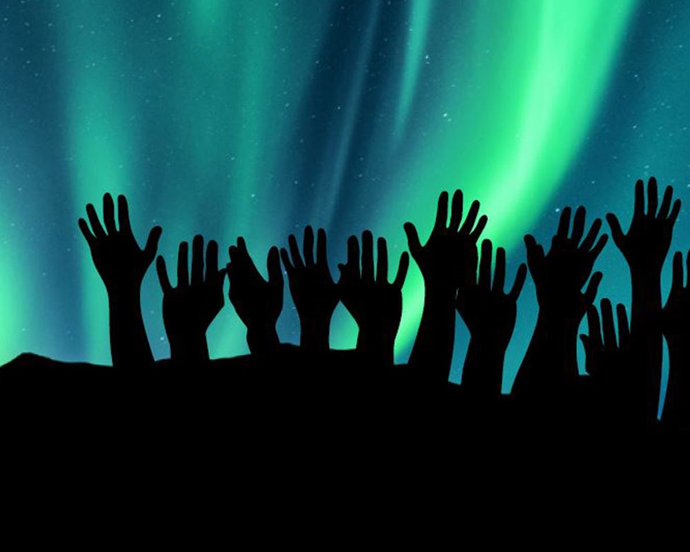 Hands outline over aurora borealis sky