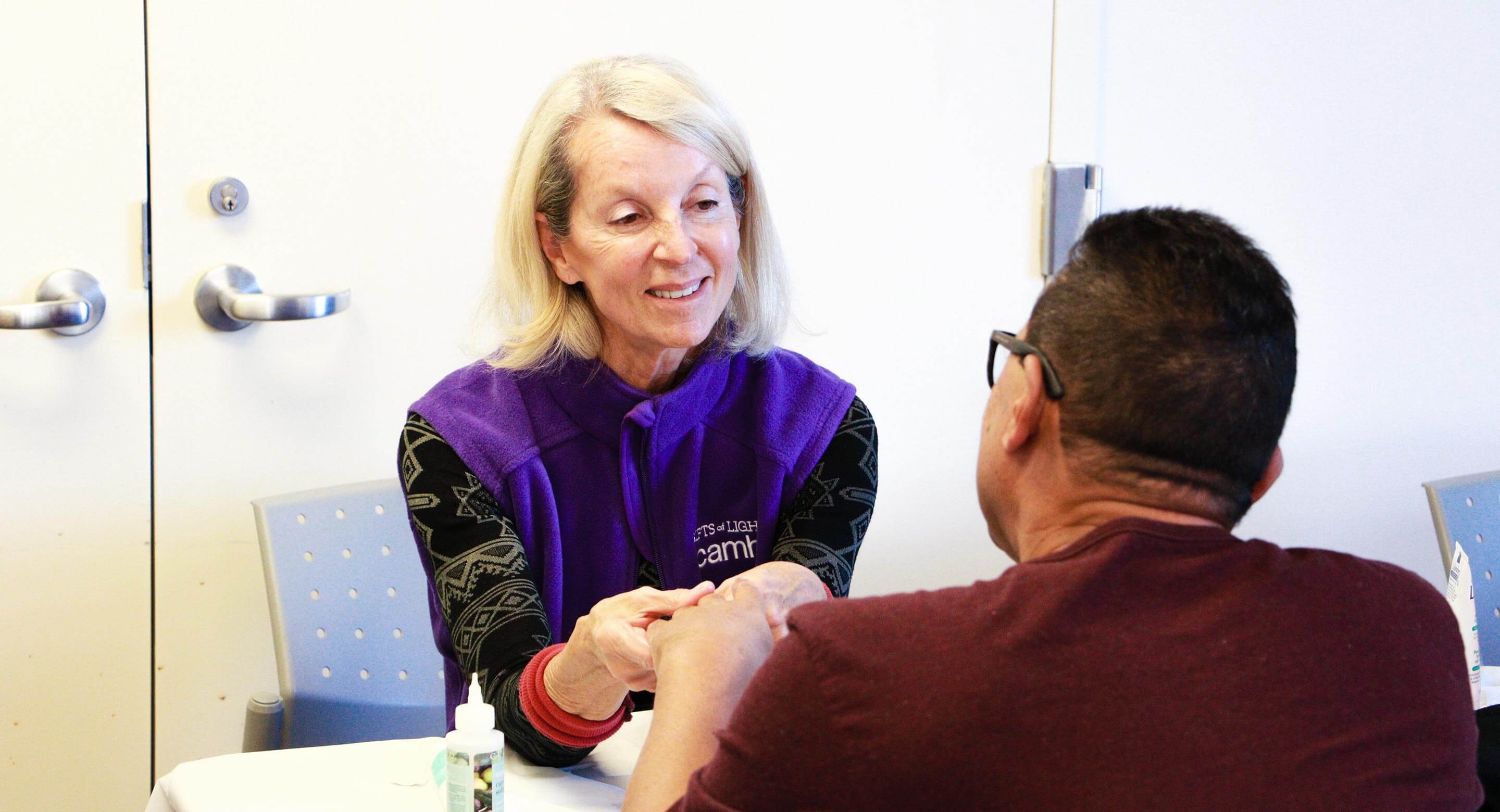 GoL volunteer Lesley Soldat gives one client a hand massage and manicure as part of the self-care event. 