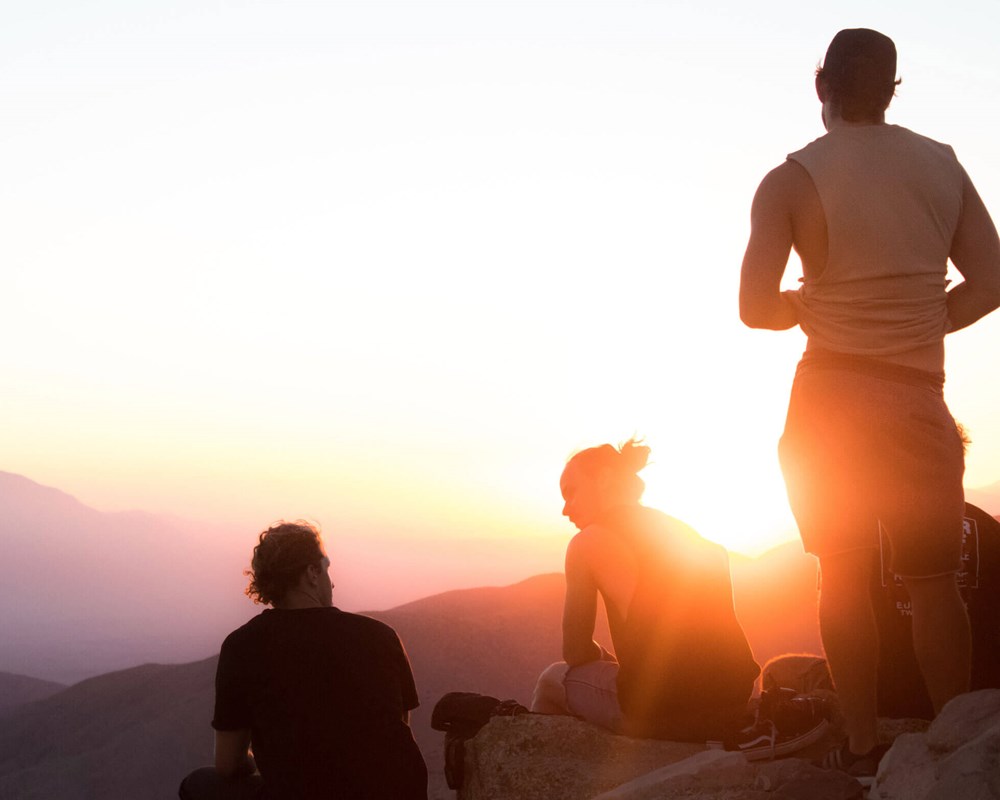 Stock photo of people in mountain watching sunrise/sunset