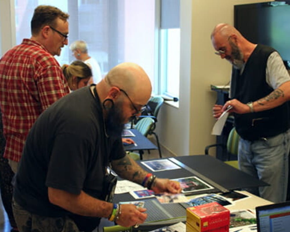 Sean (left) helps David and Peter arrange their displays in preparation for the show