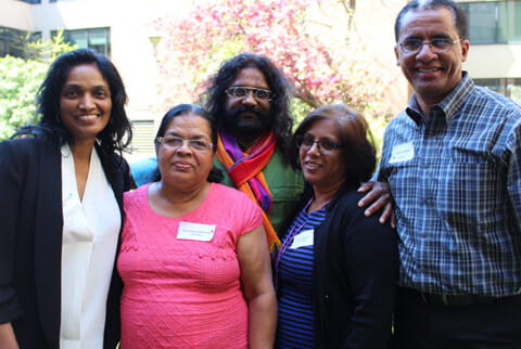 A group of South Asians standing together outside smiling at the camera 
