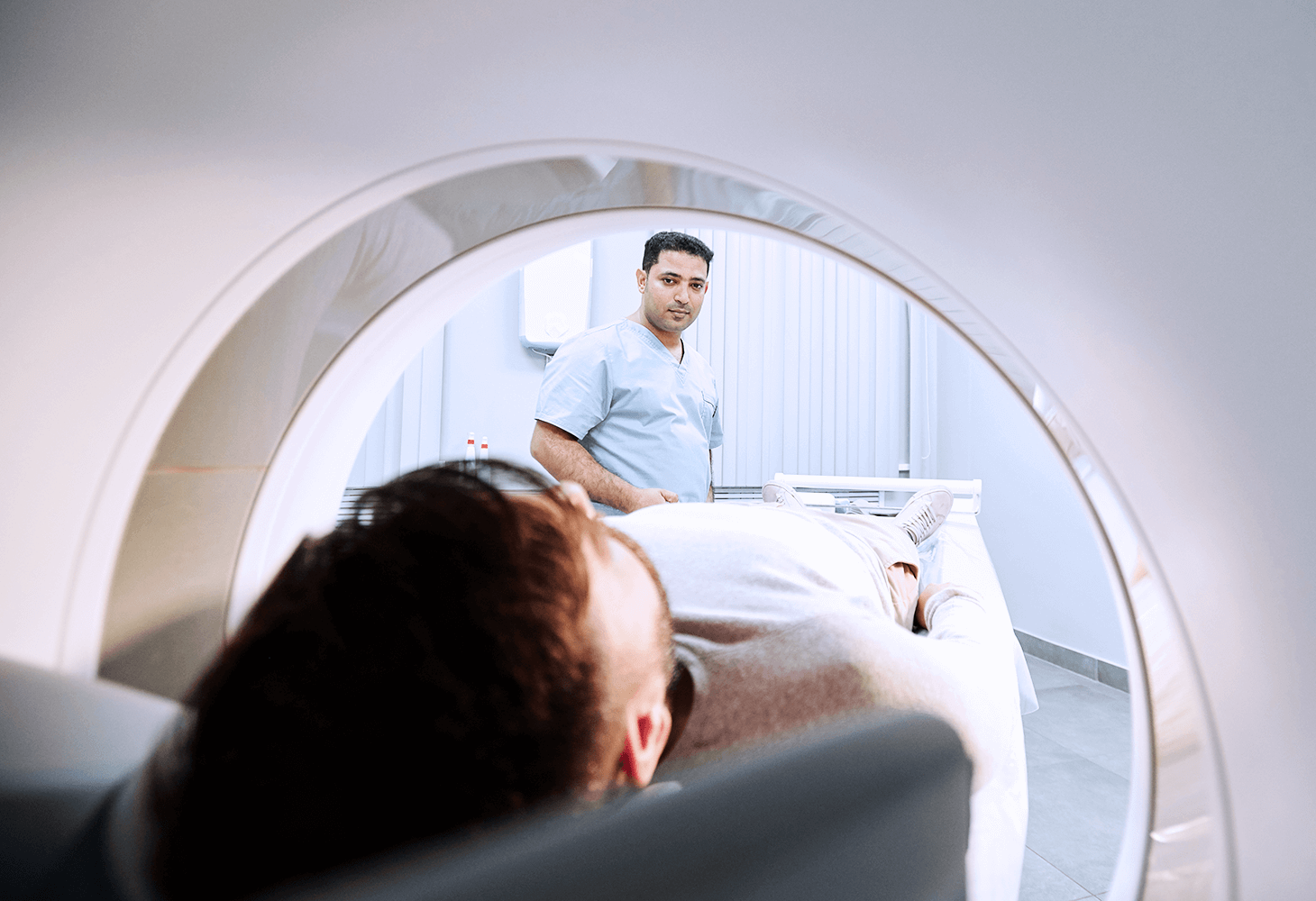 Image from inside an MRI with patient, doctor attending outside
