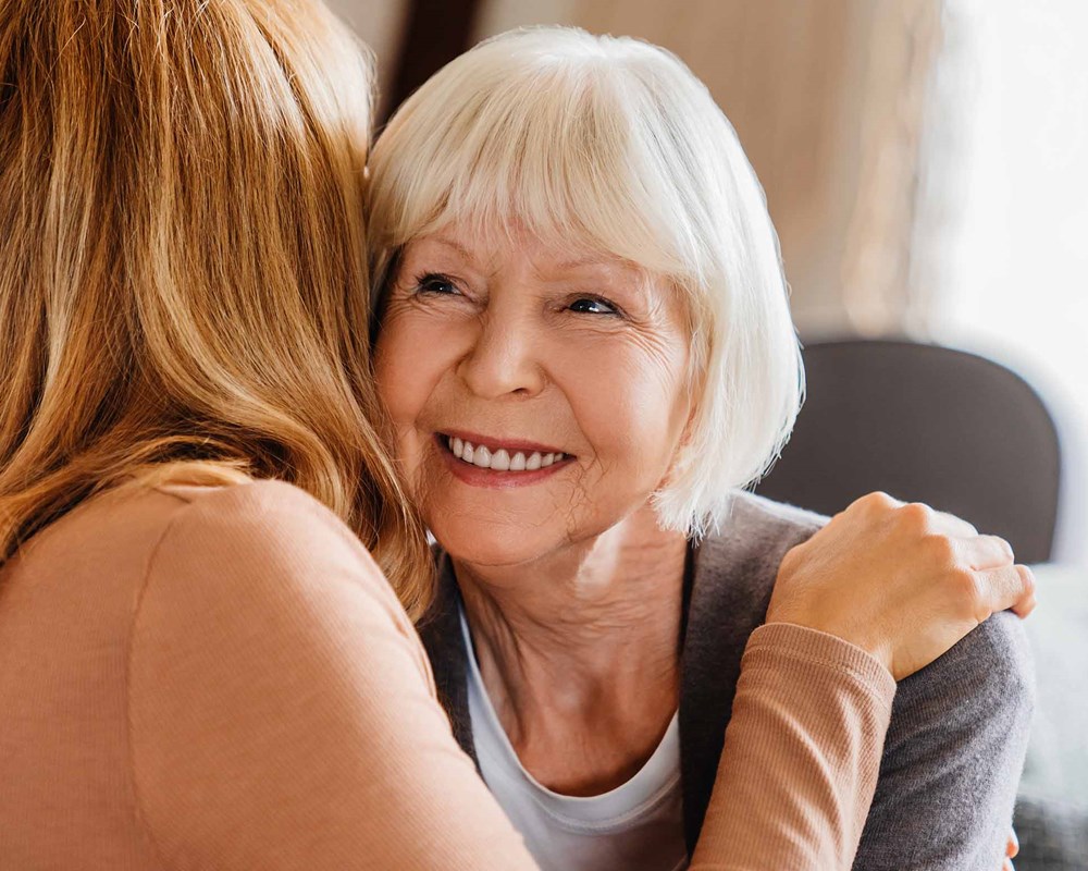 An older woman hugging a younger woman