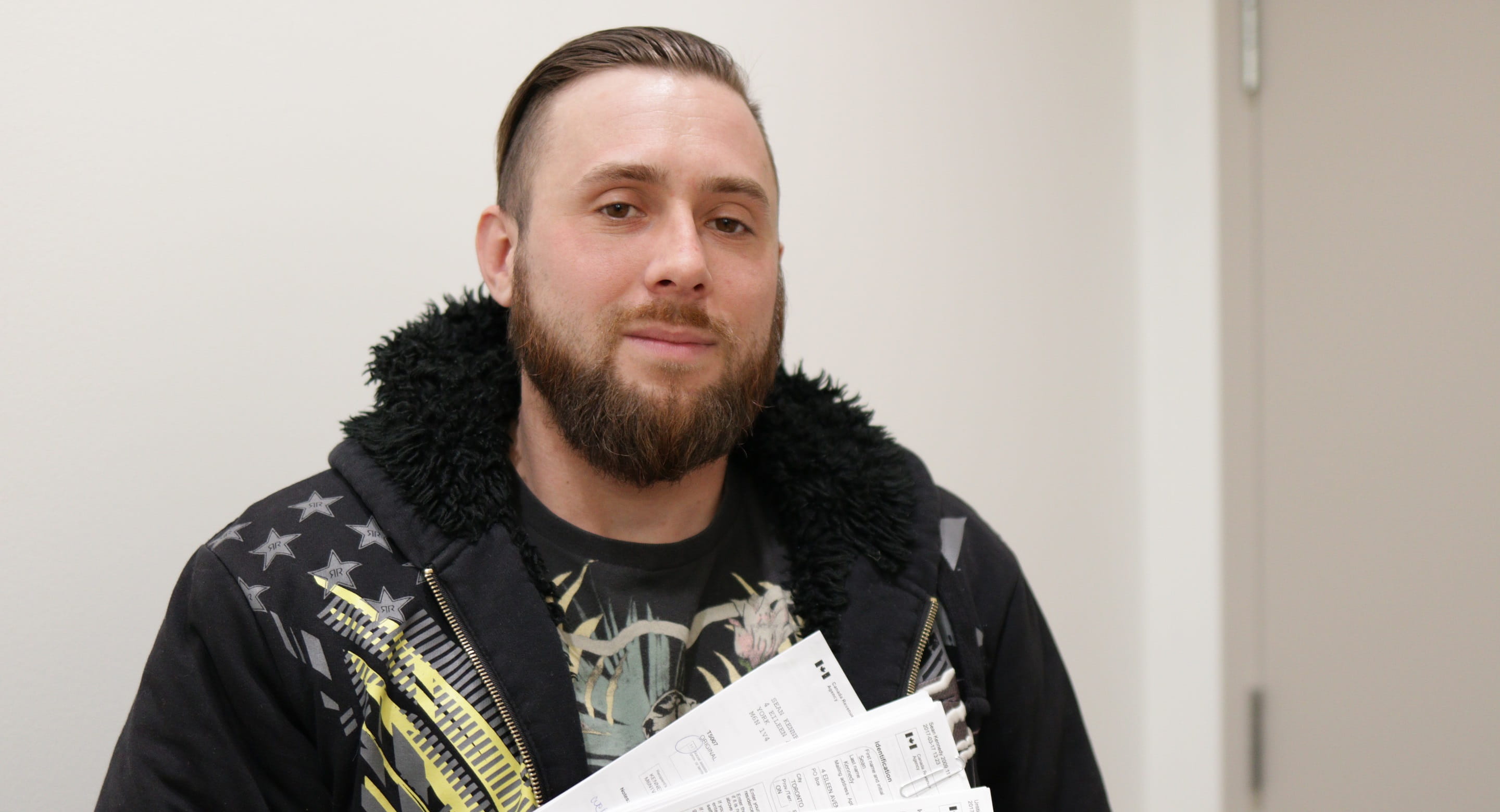 Sean holds up his completed tax forms