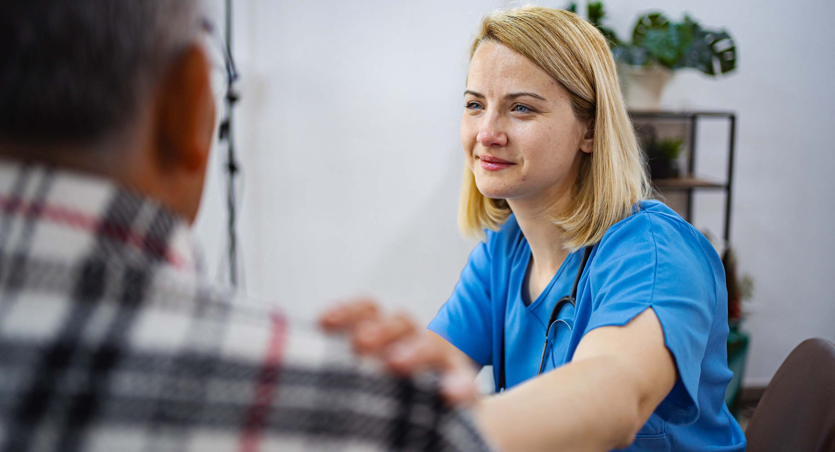 Clinician comforts a patient with their hand on the patient's shoulder