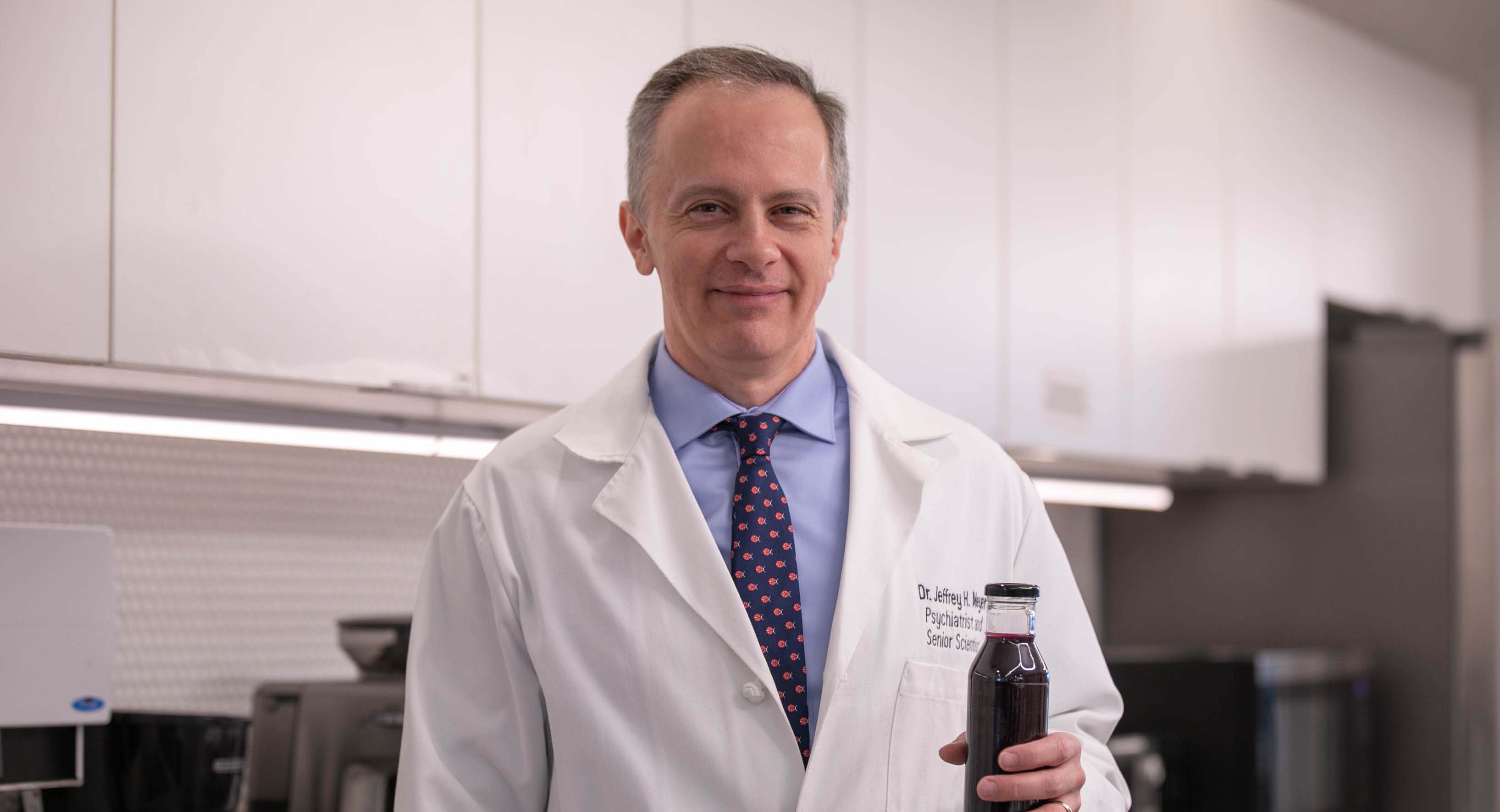 Dr. Jeff Meyer holding up his nutraceutical product