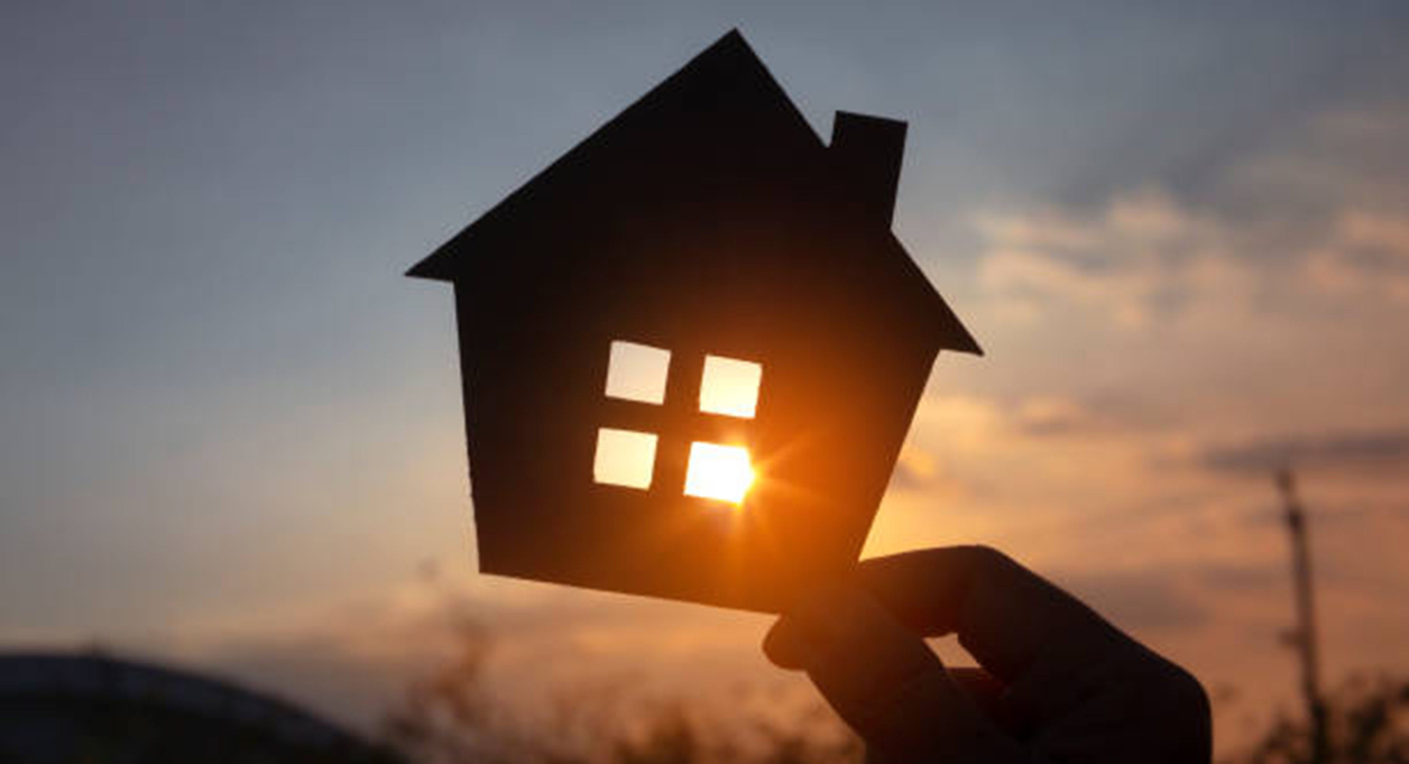 Silhouette of a house cutout, against the setting sun