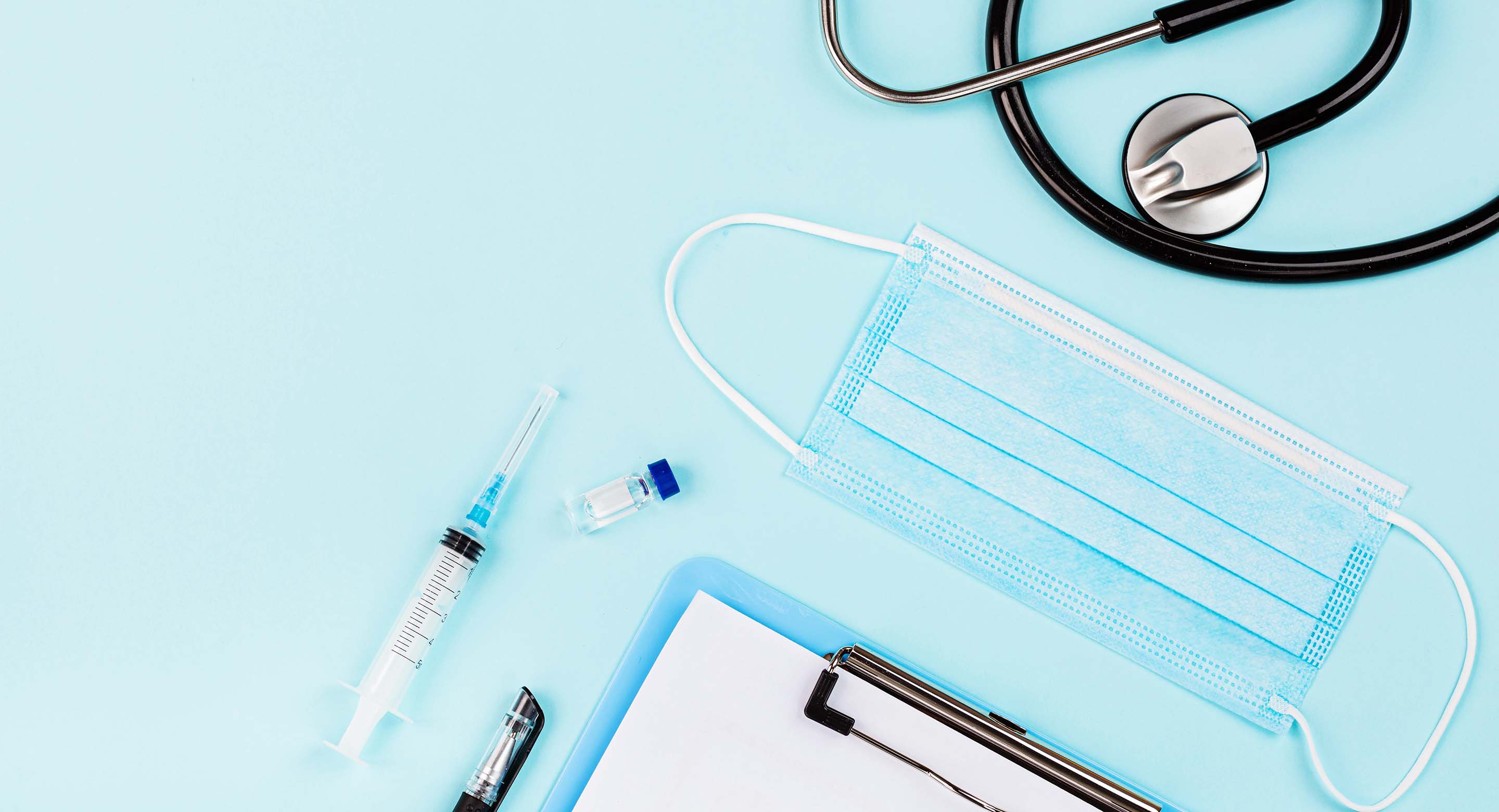 Photo of a syring, vial, mask and stethoscope