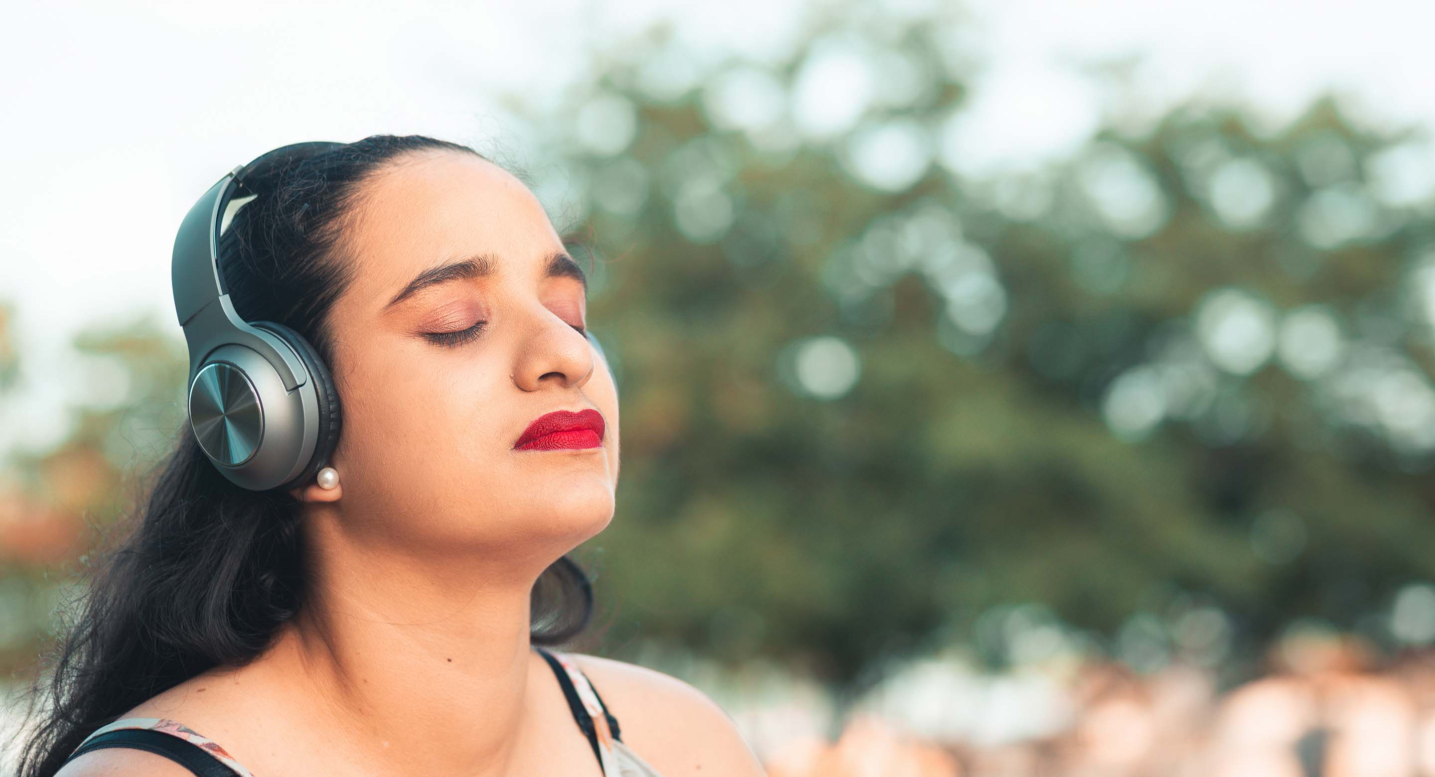Woman listening to music outdoors on headphones